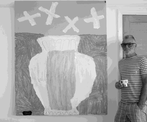 Photograph of David Pearce next to one of his paintings, 2023