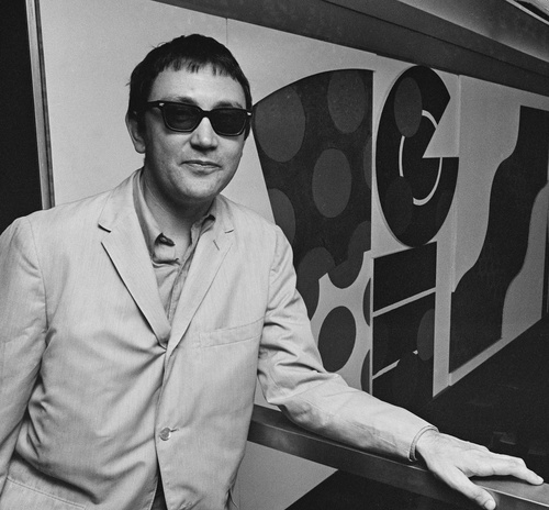 Photograph of Joe Tilson beside his mural, 1966. (Photograph: C. Maher/Express/Hulton Archive/Getty Images).